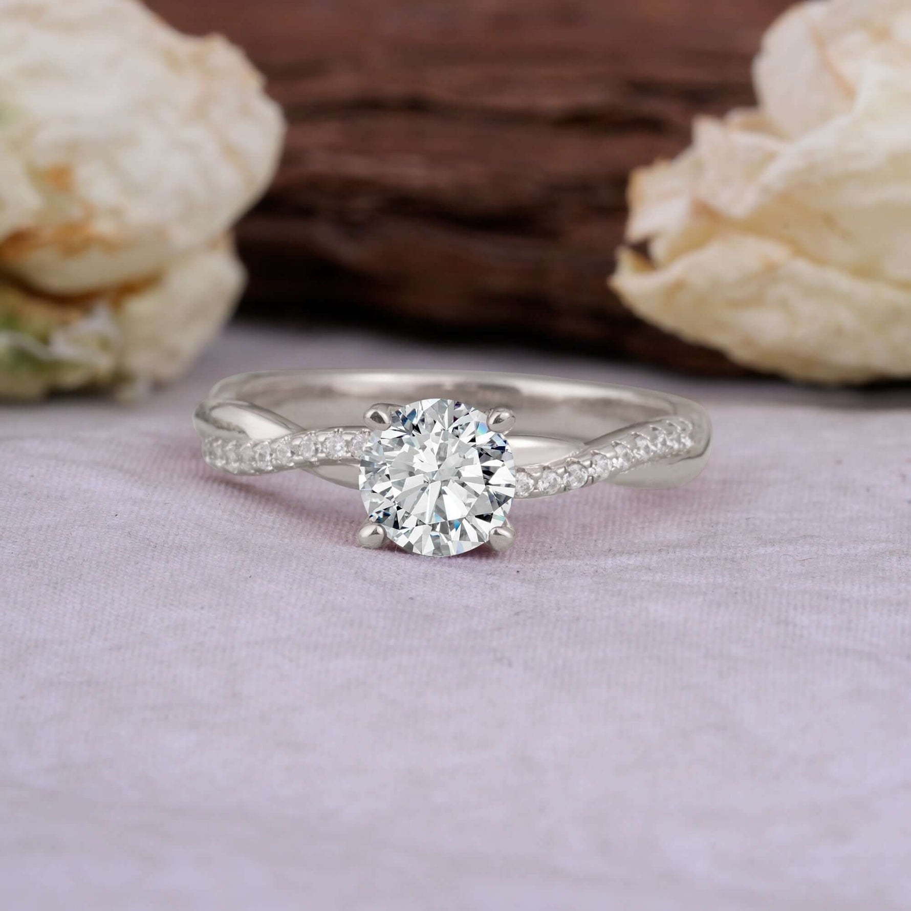 Classic Round Cut Lab Diamond Engagement Ring with Twisted Band on a soft background with flowers.