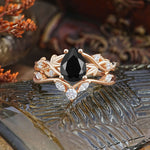 Luxury Nature-Inspired Pear Cut Vintage White 4 Prong Black Onyx Ring Pave Engagement Ring Set displayed on decorative leaves.